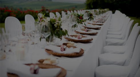 event planning photo of long white table with white chairs and place settings